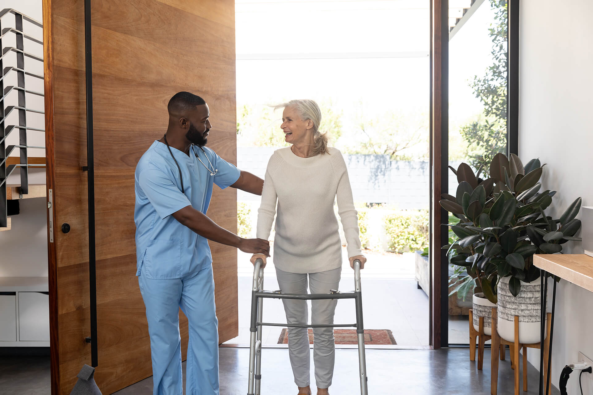 Compassionate In-Home Care in Florida - Sunshine Home Care Services Caregiver assisting senior woman with a walker at home
