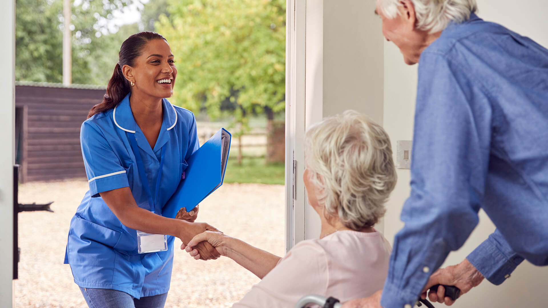 Immediate In-Home Care Services in Florida - Sunshine Home Care Services Caregiver greeting senior in wheelchair at the door with a smile