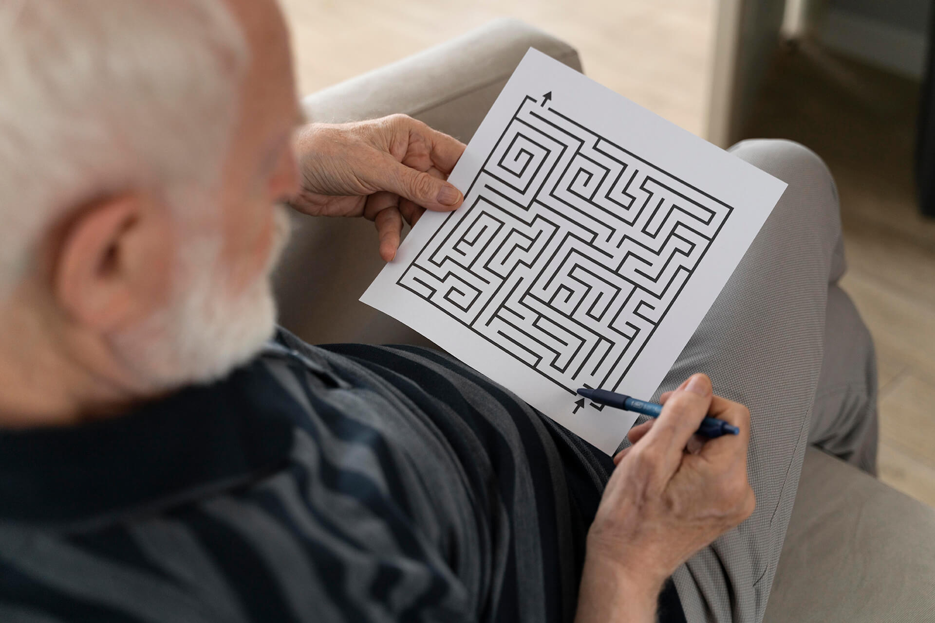 Elderly man working on a maze puzzle for cognitive stimulation