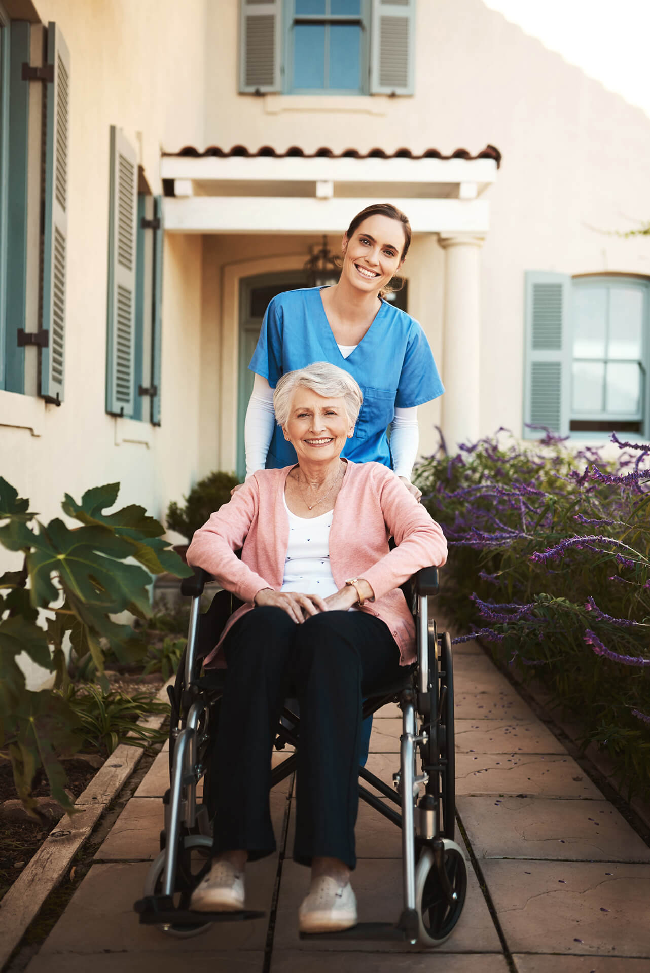 Smiling senior woman in wheelchair with supportive caregiver enjoying outdoor care at Sunshine Home Care Services Florida