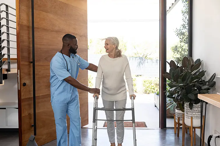 Compassionate In-Home Care in Florida - Sunshine Home Care Services Caregiver assisting senior woman with a walker at home